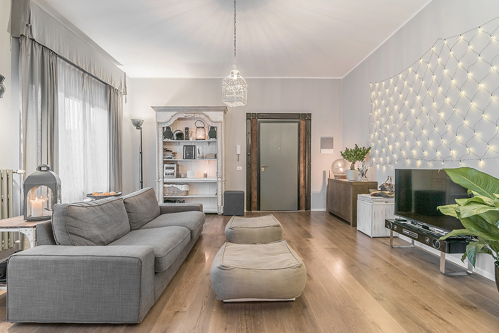 Идея дизайна: гостиная комната в скандинавском стиле с серыми стенами, светлым паркетным полом и отдельно стоящим телевизором