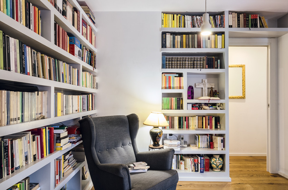 Diseño de sala de estar con biblioteca nórdica con paredes grises, suelo de madera en tonos medios y suelo marrón