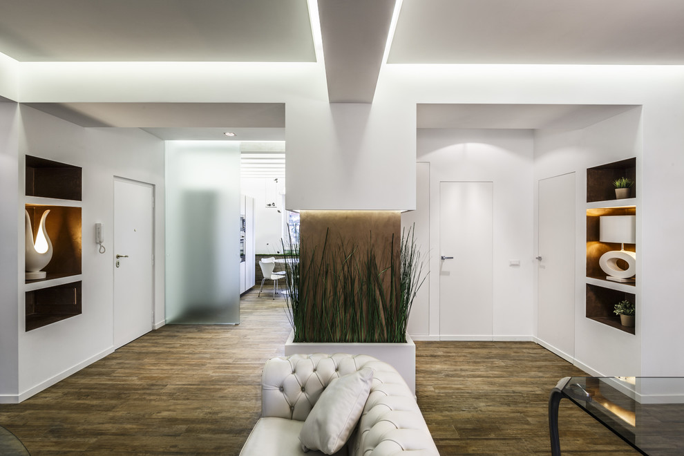 Offenes Modernes Wohnzimmer mit weißer Wandfarbe und dunklem Holzboden in Rom