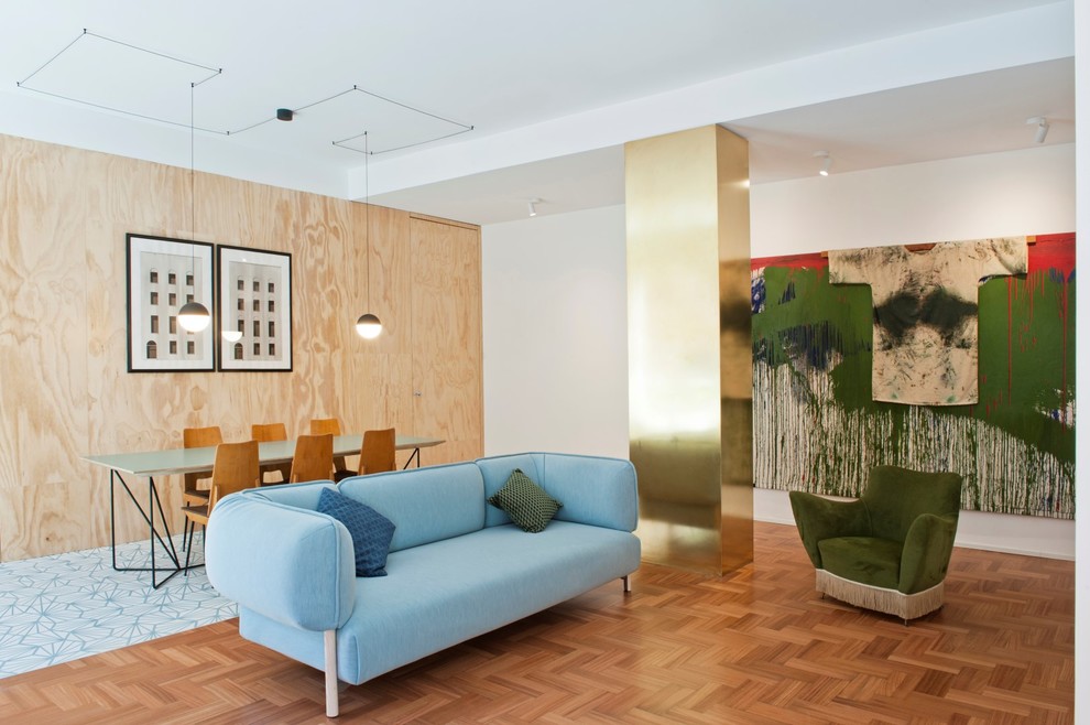 Mittelgroßes Skandinavisches Wohnzimmer mit blauer Wandfarbe, Betonboden, verstecktem TV und blauem Boden in Mailand
