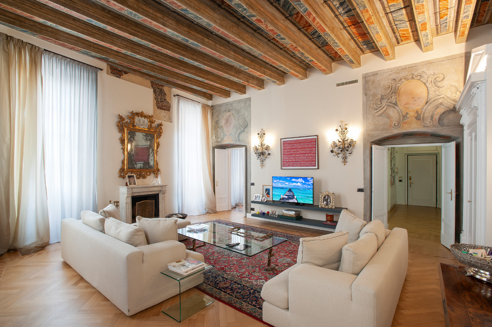 Imagen de sala de estar cerrada mediterránea extra grande con paredes blancas, suelo de madera en tonos medios, suelo marrón, todas las chimeneas, marco de chimenea de piedra y pared multimedia