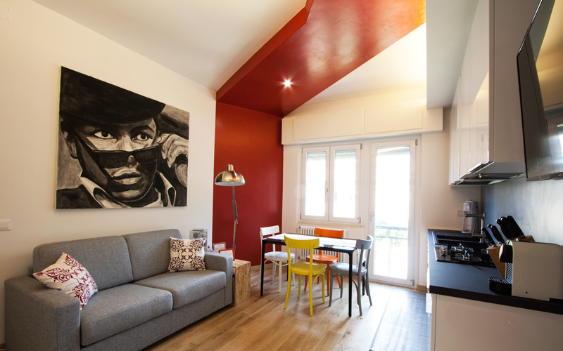 Пример оригинального дизайна: маленькая изолированная гостиная комната в стиле модернизм с разноцветными стенами, светлым паркетным полом и телевизором на стене для на участке и в саду