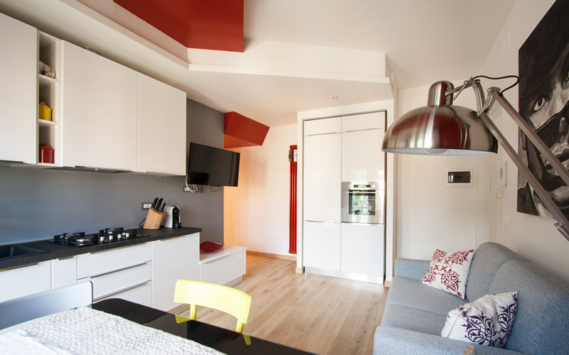Kleines, Abgetrenntes Modernes Wohnzimmer mit bunten Wänden, hellem Holzboden und TV-Wand in Rom