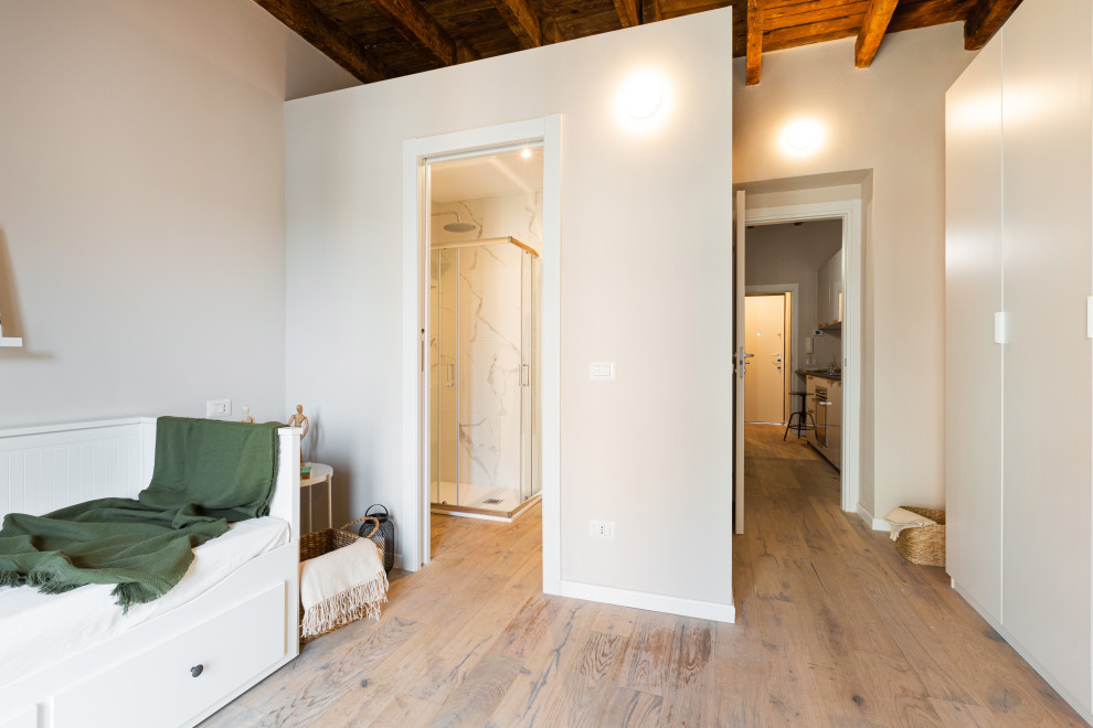 Aménagement d'un petit salon scandinave ouvert avec un mur beige, parquet clair, aucune cheminée et poutres apparentes.