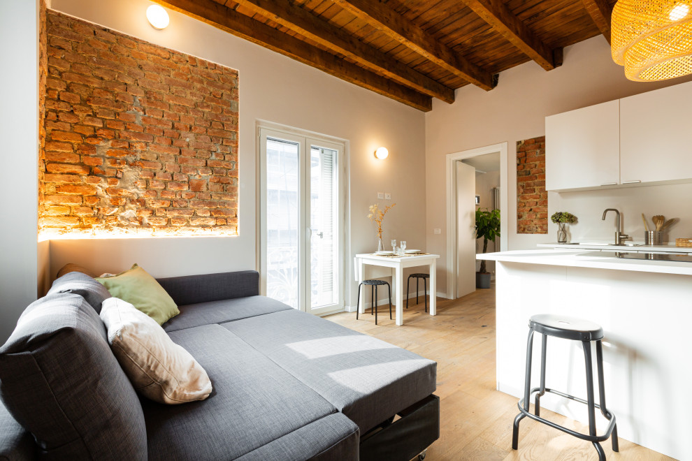Photo of a small scandi open plan living room in Milan with white walls, light hardwood flooring, no fireplace, exposed beams and brick walls.