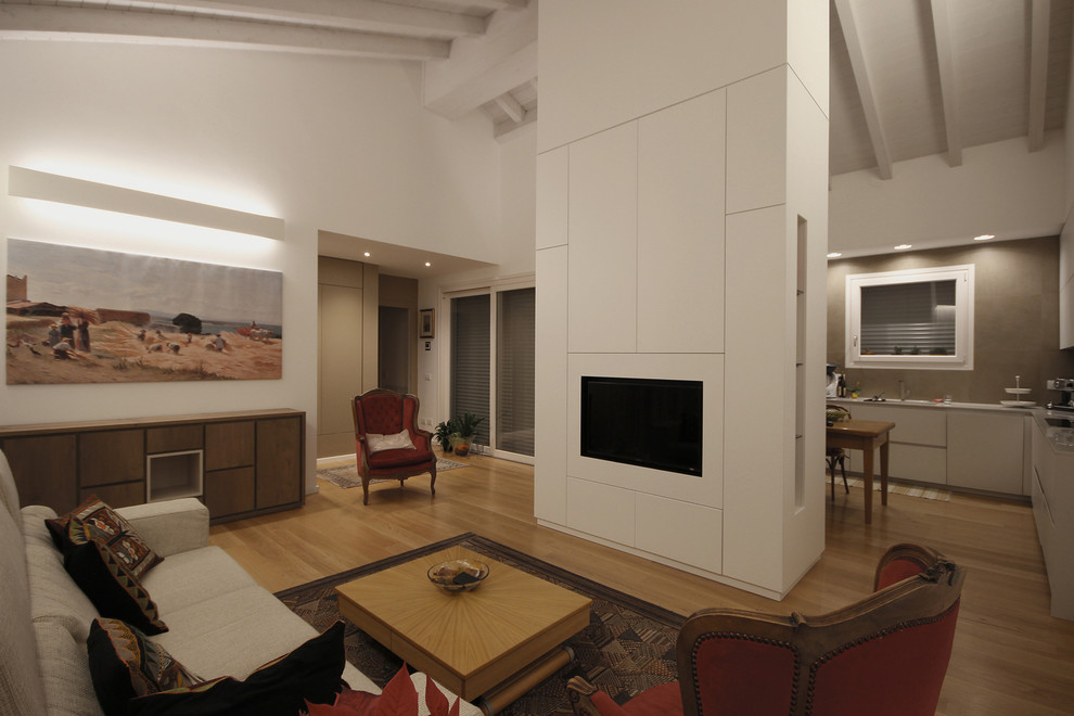 Réalisation d'un salon design de taille moyenne et ouvert avec une salle de réception, un mur blanc, un sol en bois brun, un téléviseur encastré et un sol marron.