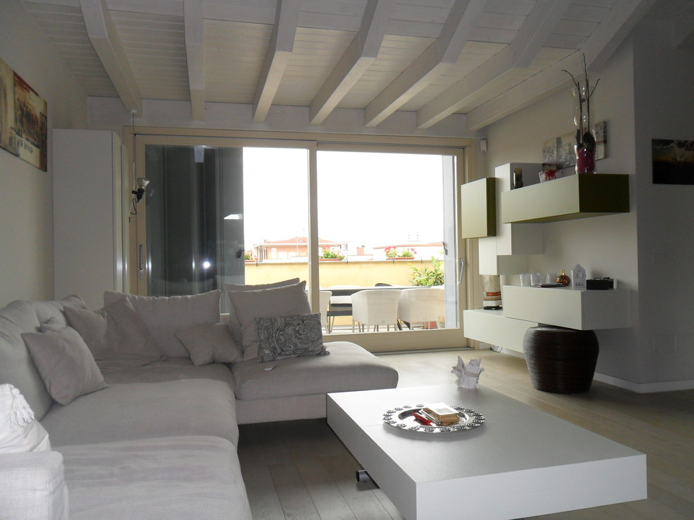 Esempio di un grande soggiorno contemporaneo aperto con pareti bianche, pavimento in legno verniciato e TV a parete