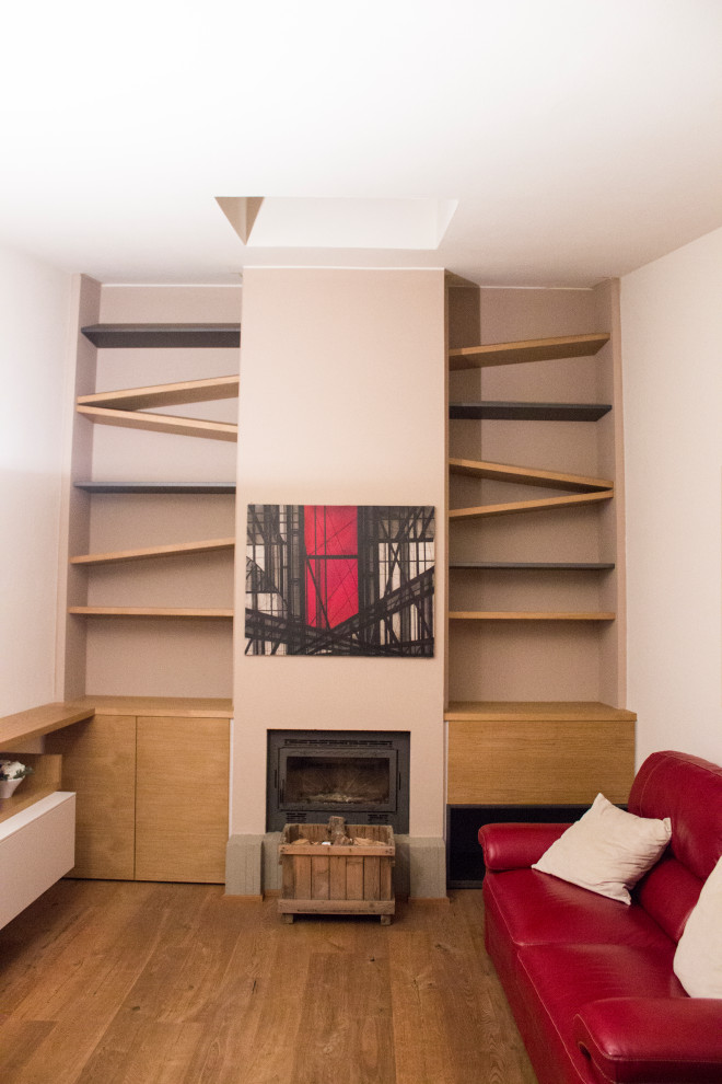 Foto di un soggiorno design di medie dimensioni e aperto con libreria, pareti bianche, pavimento in legno massello medio, stufa a legna e TV a parete