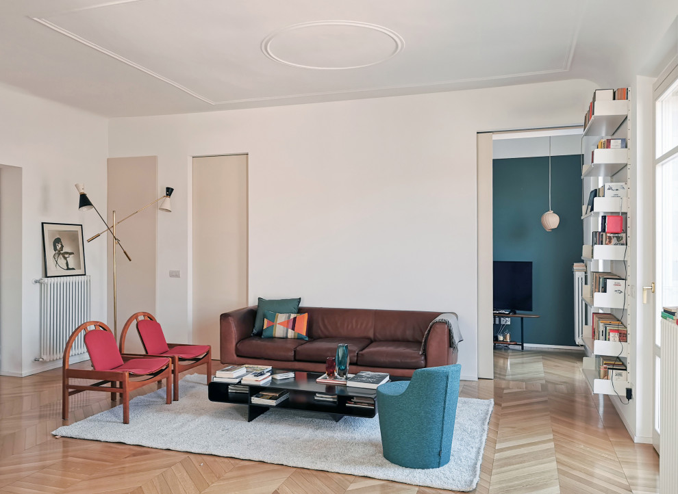 На фото: гостиная комната в современном стиле с белыми стенами, светлым паркетным полом, бежевым полом и коричневым диваном