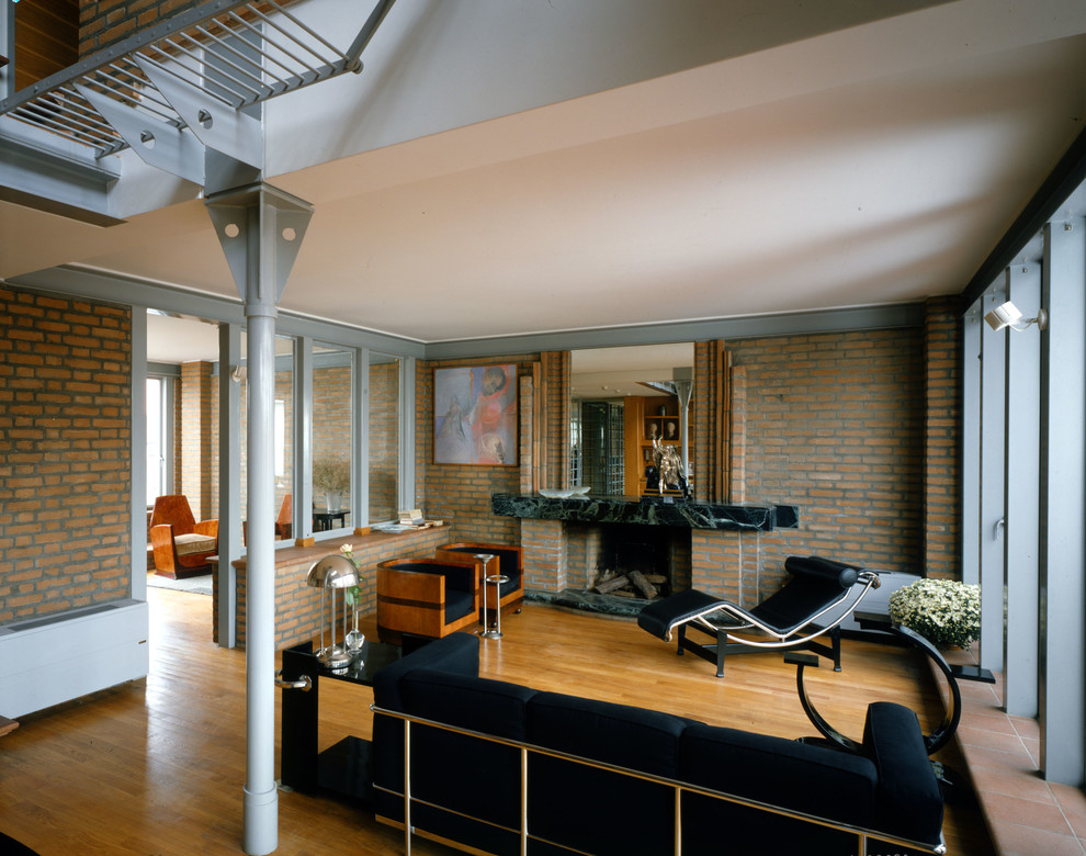 Foto di un soggiorno contemporaneo di medie dimensioni e stile loft con pareti bianche, parquet chiaro, camino classico, cornice del camino in mattoni e pavimento marrone