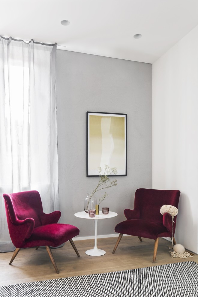 Стильный дизайн: гостиная комната в скандинавском стиле с серыми стенами и светлым паркетным полом - последний тренд