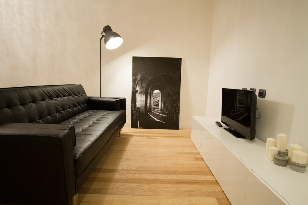 Ispirazione per un soggiorno tradizionale di medie dimensioni con pareti bianche, pavimento in legno massello medio, TV a parete e pavimento nero