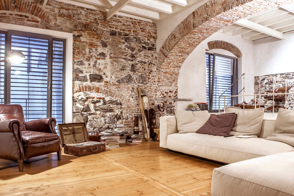 Imagen de sala de estar industrial de tamaño medio con paredes blancas y suelo de madera clara