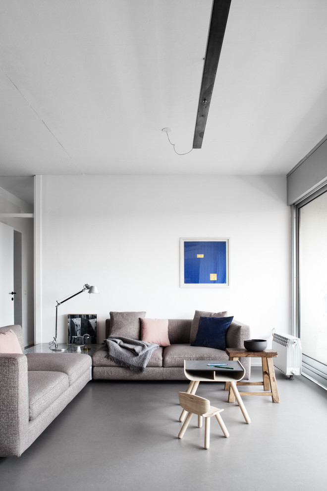 Foto de salón abierto actual de tamaño medio con paredes blancas, suelo de cemento y suelo gris
