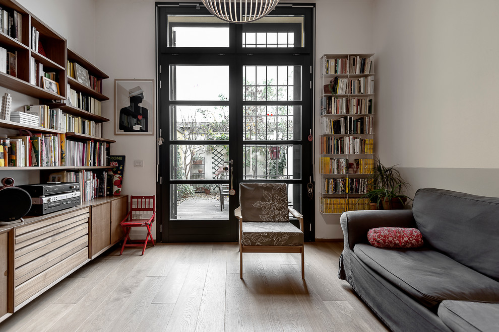 This is an example of a scandinavian living room in Milan with white walls and light hardwood flooring.