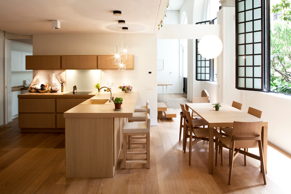 Cette image montre un grand salon design ouvert avec un mur blanc et un sol en bois brun.