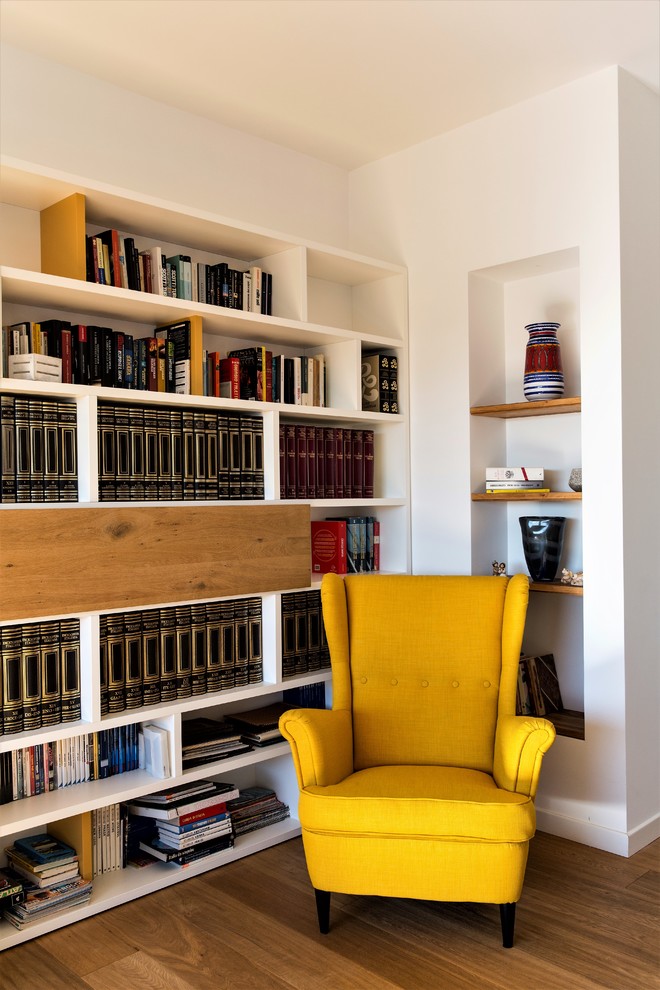Mittelgroße, Offene Moderne Bibliothek mit weißer Wandfarbe, hellem Holzboden, TV-Wand und braunem Boden in Rom