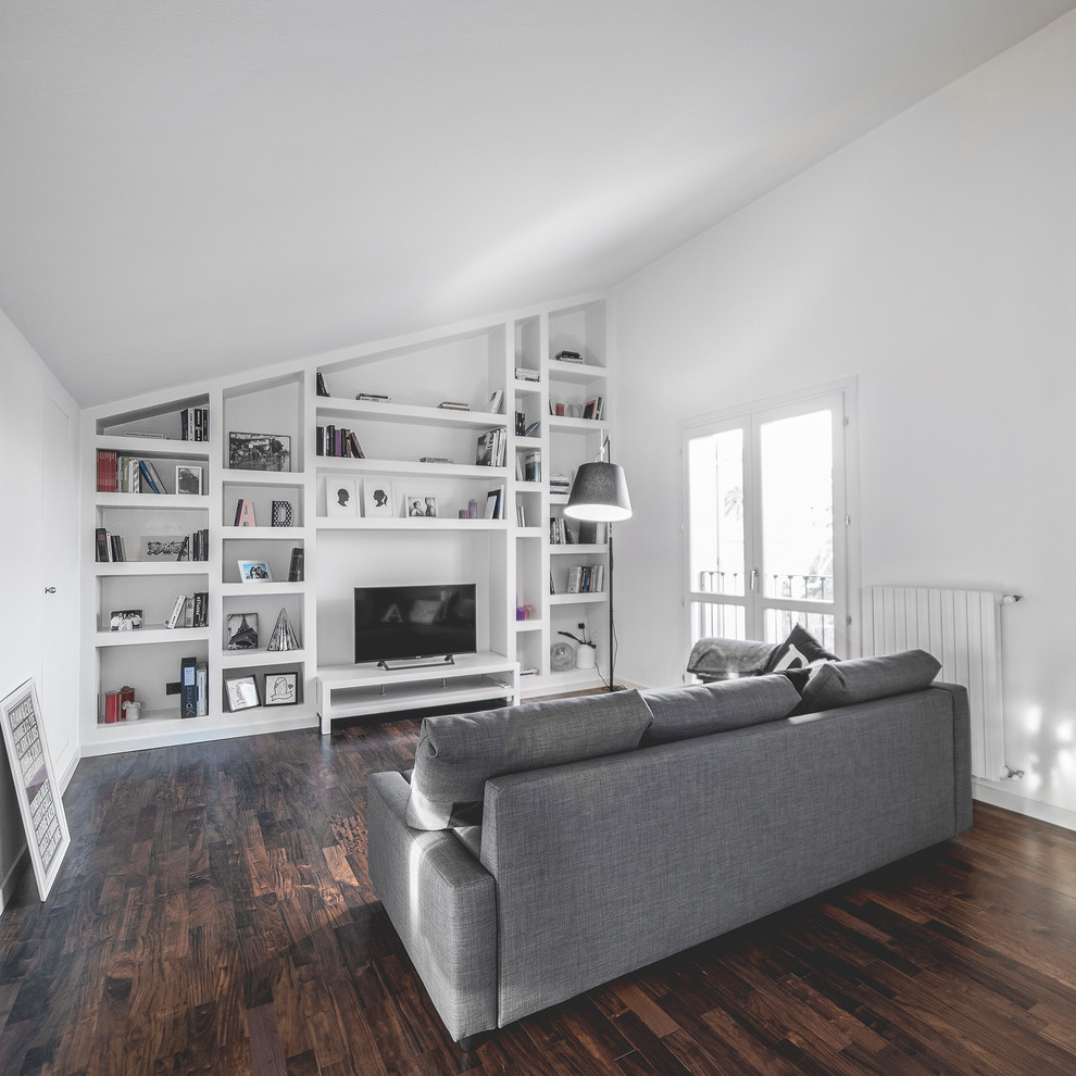 Immagine di un soggiorno minimal con libreria, pareti bianche e pavimento in legno massello medio