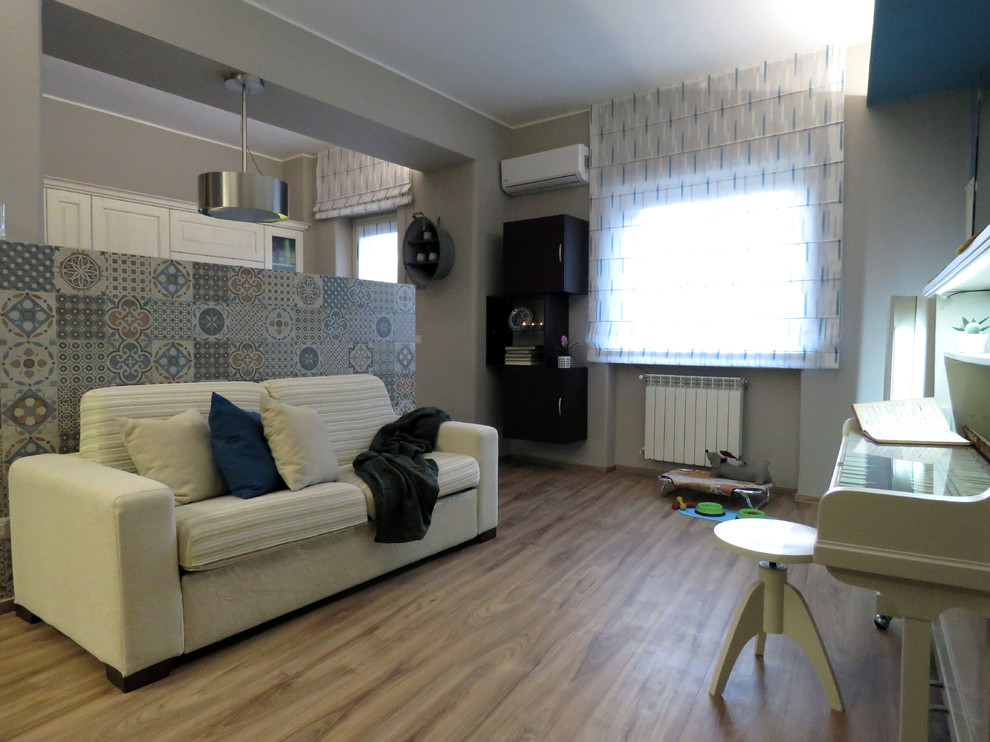 Idee per un piccolo soggiorno eclettico aperto con pareti multicolore, pavimento in laminato, TV autoportante e pavimento marrone