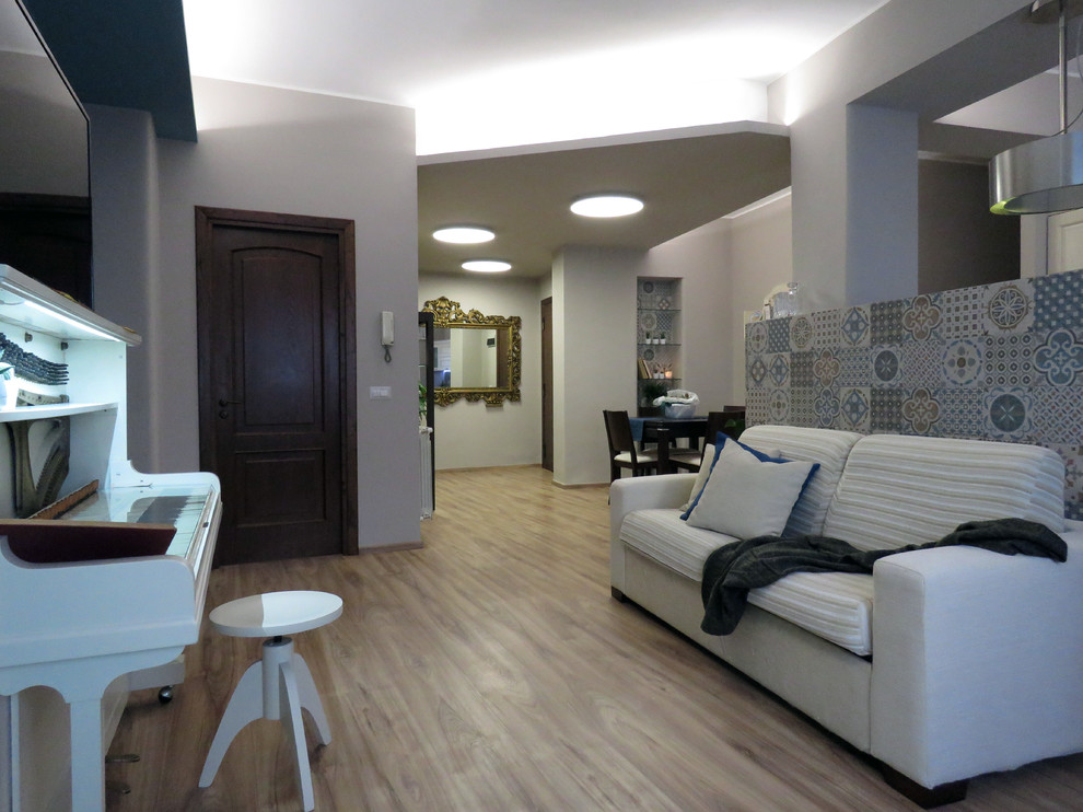 Idee per un piccolo soggiorno bohémian aperto con pareti multicolore, pavimento in laminato, TV autoportante e pavimento marrone