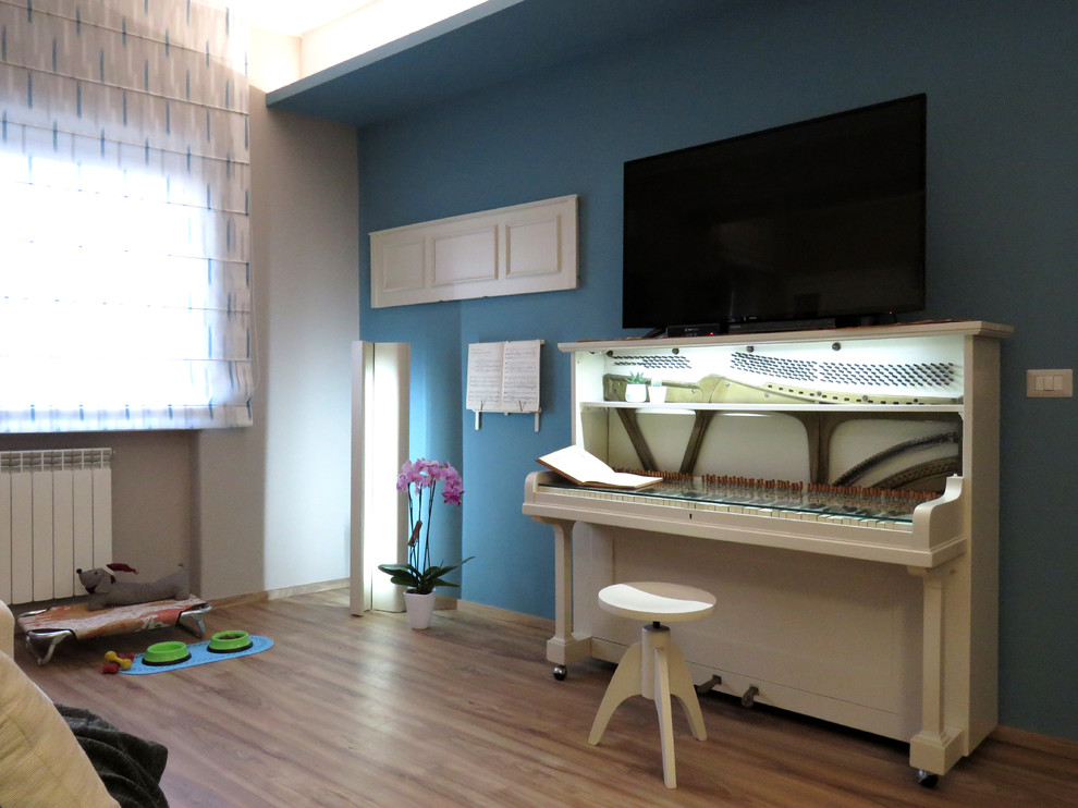 Modelo de salón abierto bohemio pequeño con paredes multicolor, suelo laminado, televisor independiente y suelo marrón