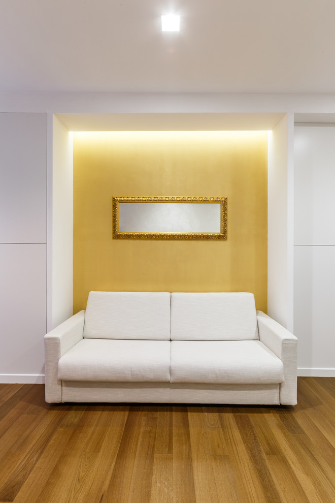 Foto de salón actual con paredes amarillas y suelo de madera en tonos medios