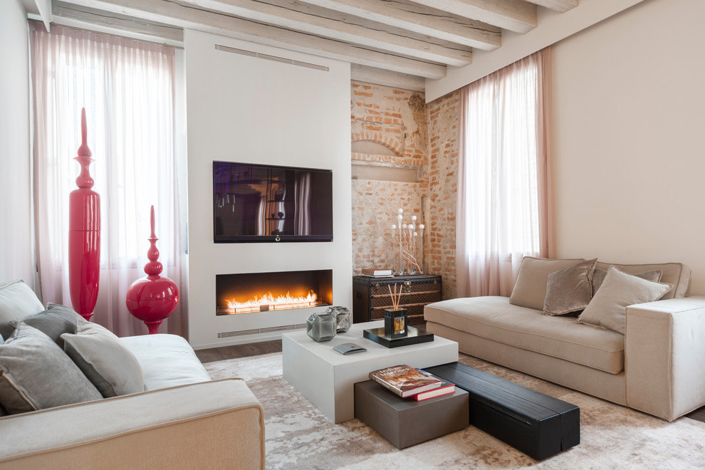 Imagen de salón abierto contemporáneo con paredes beige, todas las chimeneas, televisor colgado en la pared y marco de chimenea de yeso