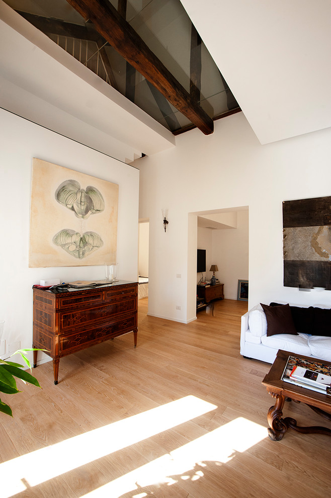 Immagine di un grande soggiorno design stile loft con pareti bianche, parquet chiaro e TV a parete