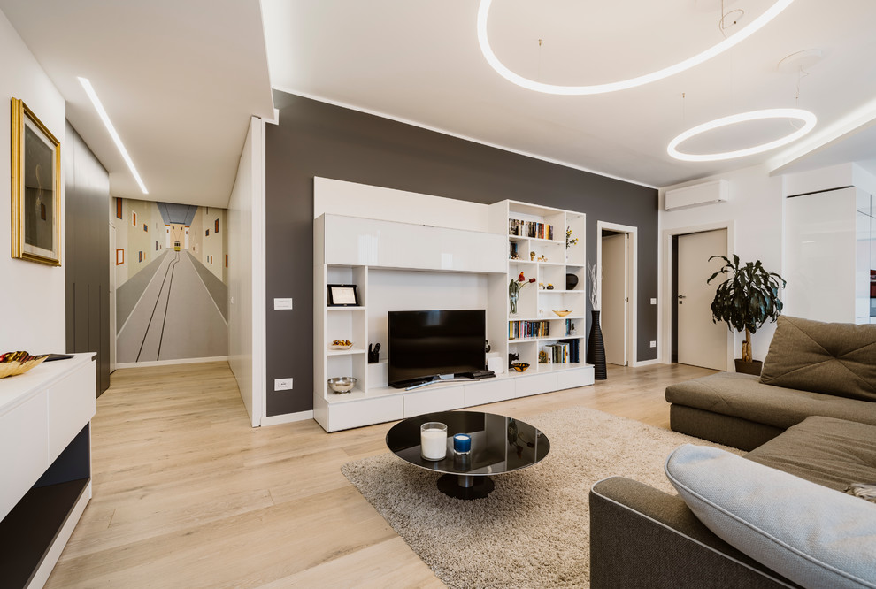Aménagement d'un grand salon contemporain ouvert avec un mur gris, parquet clair, un téléviseur encastré et un sol beige.