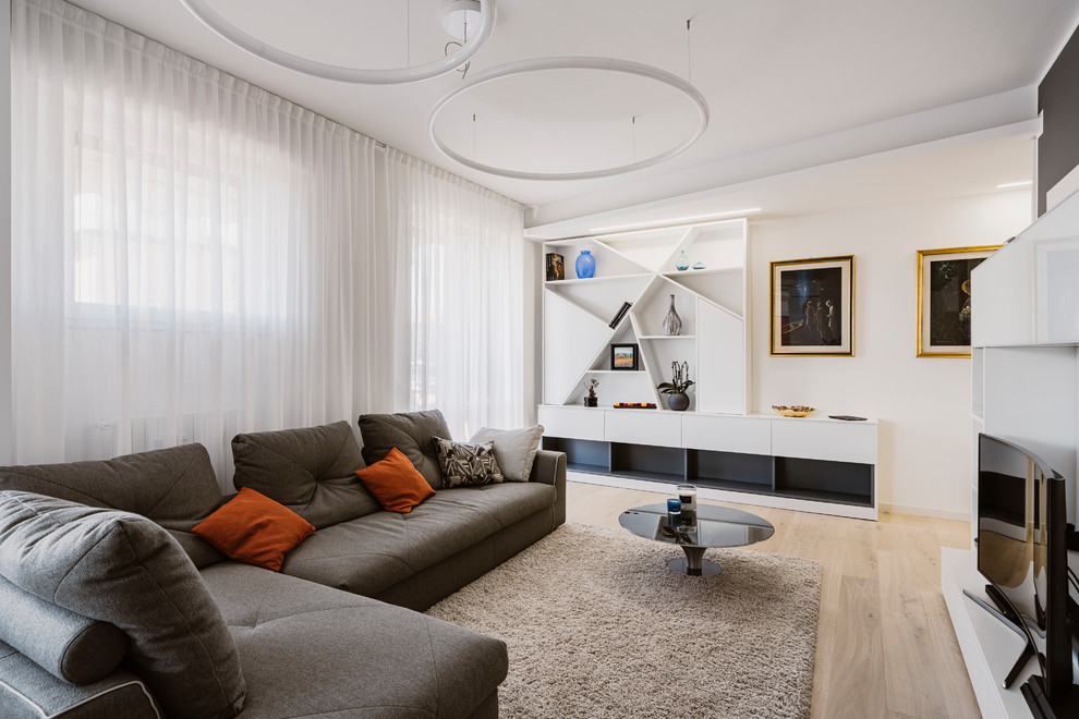Immagine di un grande soggiorno contemporaneo aperto con pareti grigie, parquet chiaro, parete attrezzata e pavimento beige