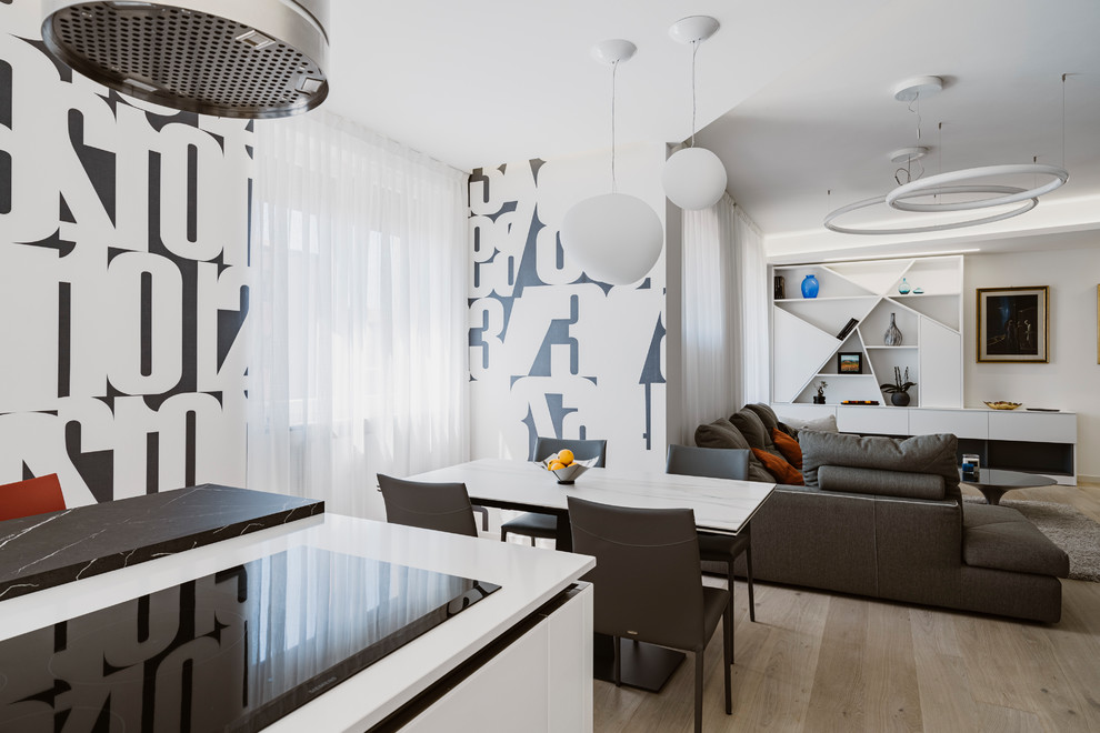 Cette image montre un grand salon design ouvert avec un mur gris, parquet clair, un téléviseur encastré et un sol beige.