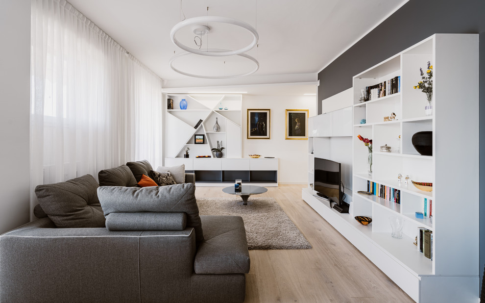 Großes, Offenes Modernes Wohnzimmer mit hellem Holzboden, Multimediawand, beigem Boden und grauer Wandfarbe in Mailand