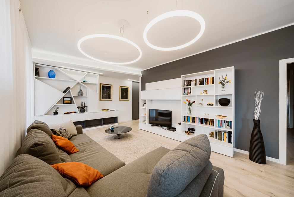 Foto di un grande soggiorno minimal aperto con pareti grigie, parquet chiaro, parete attrezzata e pavimento beige