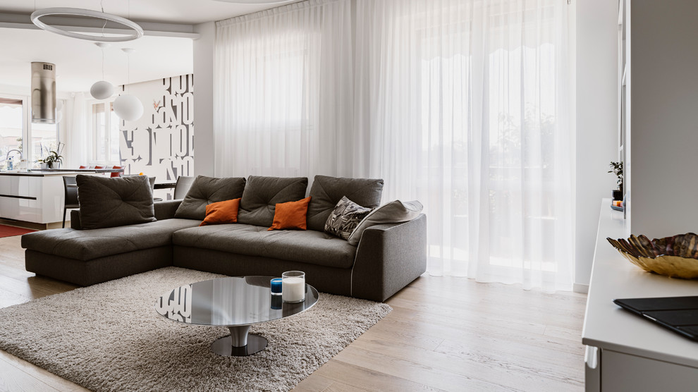 Immagine di un grande soggiorno minimal aperto con pareti grigie, parquet chiaro, parete attrezzata e pavimento beige