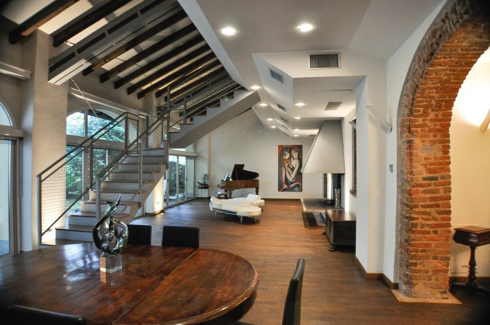 Photo of an expansive modern open plan living room in Other with dark hardwood flooring, a two-sided fireplace, a metal fireplace surround, a wall mounted tv and brown floors.