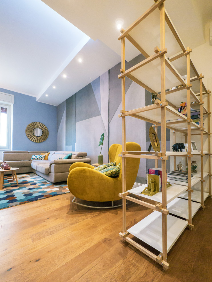 Foto di un soggiorno contemporaneo di medie dimensioni e aperto con pareti blu, pavimento in legno massello medio, TV a parete, pavimento marrone e libreria