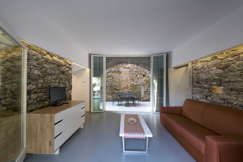 Immagine di un soggiorno contemporaneo di medie dimensioni e aperto con sala formale, pareti bianche, pavimento in cemento, TV a parete e pavimento grigio