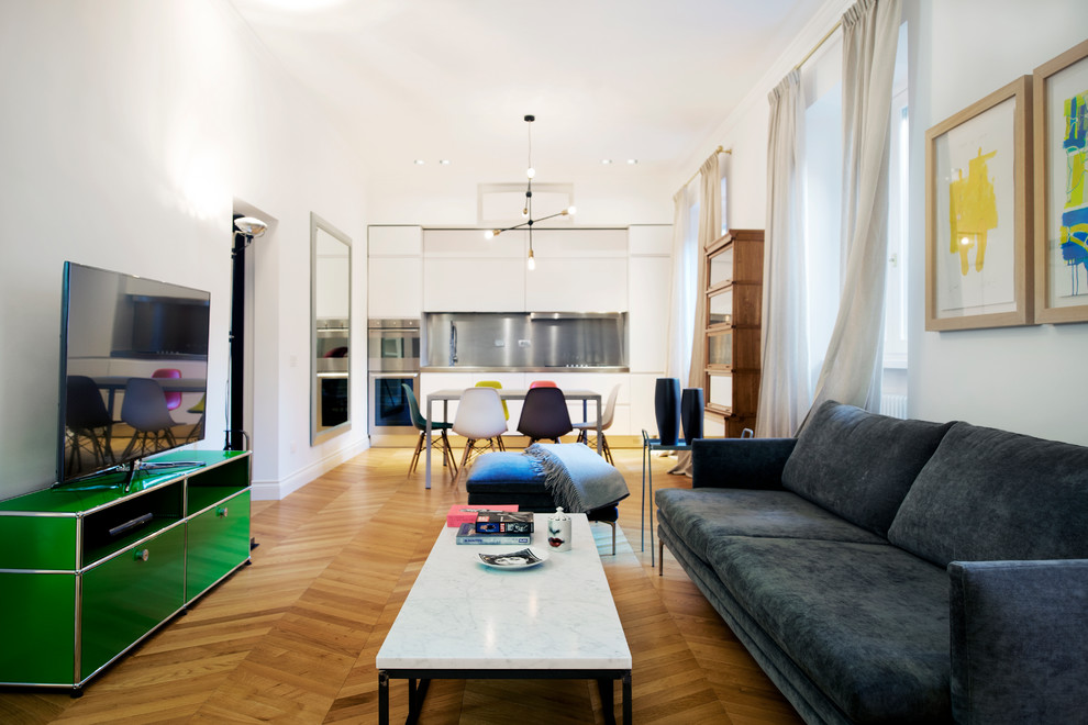 Großes, Offenes Retro Wohnzimmer mit weißer Wandfarbe, braunem Holzboden und freistehendem TV in Rom