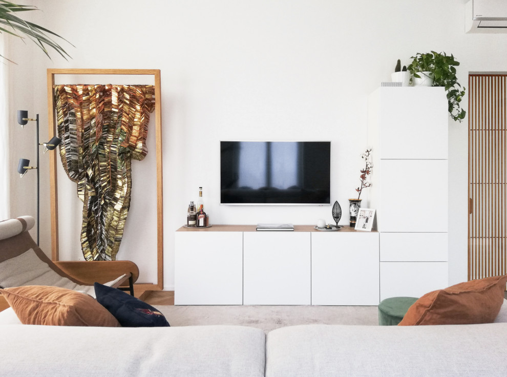 Skandinavisk inredning av ett allrum med öppen planlösning, med en väggmonterad TV