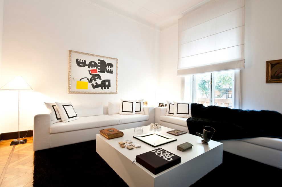 Example of a large classic formal medium tone wood floor living room design in Milan with white walls