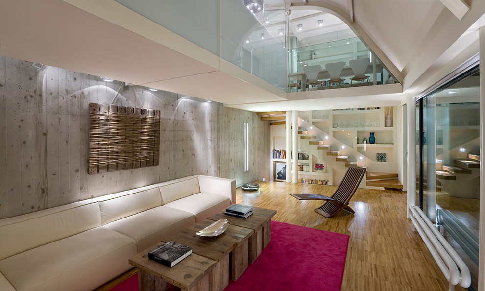 Immagine di un grande soggiorno contemporaneo aperto con libreria, pareti multicolore, pavimento in legno massello medio e pavimento marrone