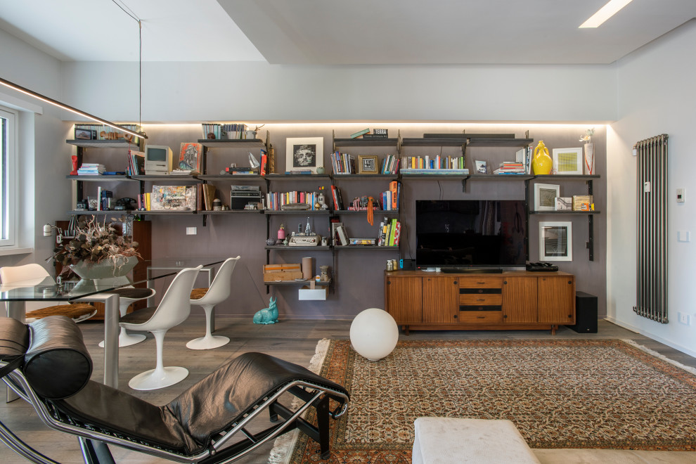 Idee per un soggiorno eclettico con libreria, pareti viola, parquet scuro e parete attrezzata