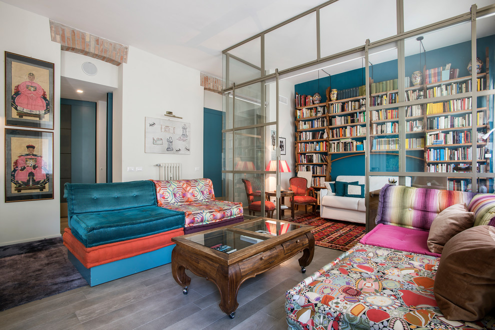 Immagine di un soggiorno etnico con libreria, pareti blu, pavimento grigio e tappeto