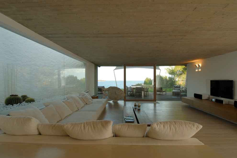 Esempio di un soggiorno contemporaneo aperto e di medie dimensioni con pareti bianche, parquet chiaro, parete attrezzata e pavimento beige