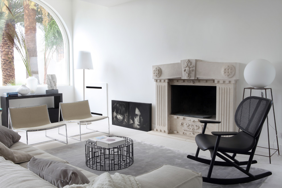 Cette photo montre un salon méditerranéen fermé avec un mur blanc, une cheminée standard et un manteau de cheminée en pierre.