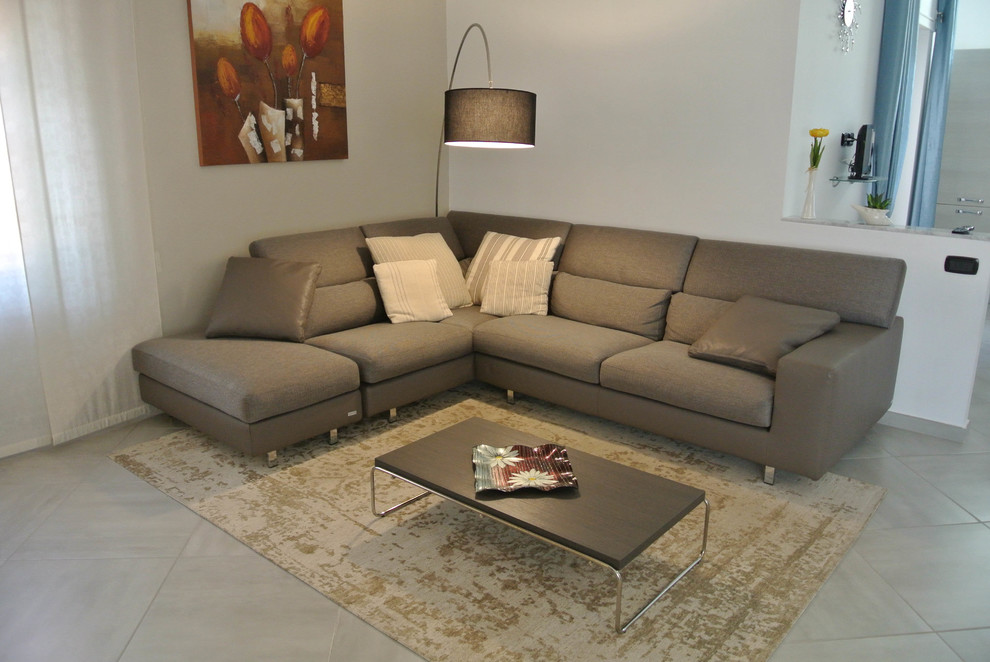 Esempio di un ampio soggiorno design aperto con pareti beige e pavimento in gres porcellanato