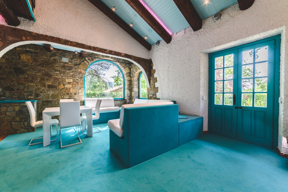 Cette image montre un salon minimaliste de taille moyenne et ouvert avec une salle de réception, un mur blanc, moquette, une cheminée standard, un manteau de cheminée en brique, un téléviseur dissimulé et un sol turquoise.
