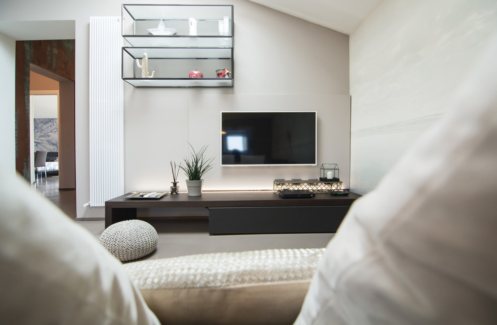 Immagine di un soggiorno contemporaneo di medie dimensioni e aperto con pareti beige, pavimento in cemento, TV a parete e pavimento beige
