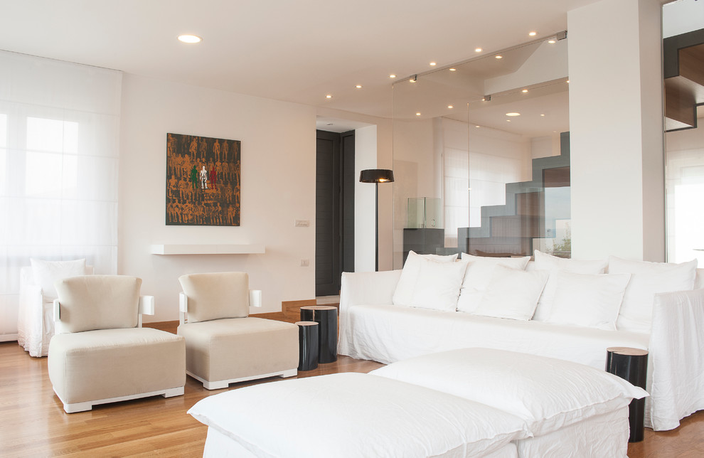 Diseño de salón abierto actual con paredes blancas y suelo de madera clara