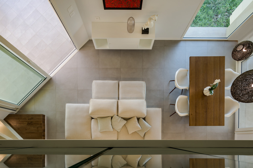 Idee per un ampio soggiorno contemporaneo stile loft con pareti bianche, pavimento grigio e travi a vista